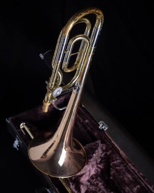 Yamaha YBL-421G Bas Trombonu Koyu Kadife Çizgili Sert Davada F Eklentisiyle koyu siyah arka planda tam çekim 1