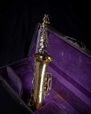 Buescher Alto Sax, Deep Purple Velvet-Lined Hard Case 'de siyah arka planda altın madalya kazandı
