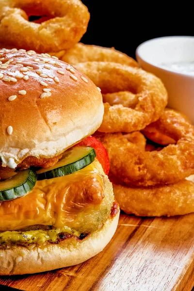 Tahta bir masanın üstünde oturan bir hamburgerin yakın çekimi.