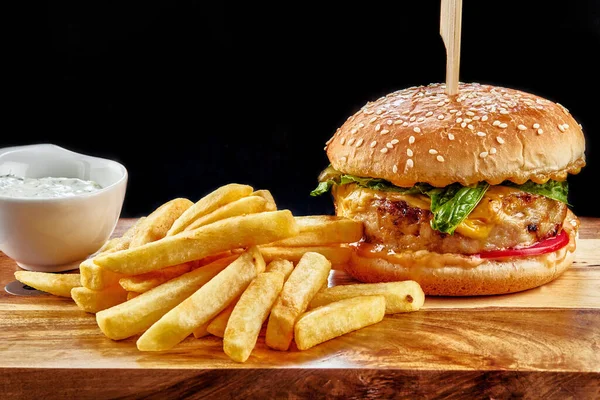 Tahta bir masanın üstünde oturan bir hamburgerin yakın çekimi.