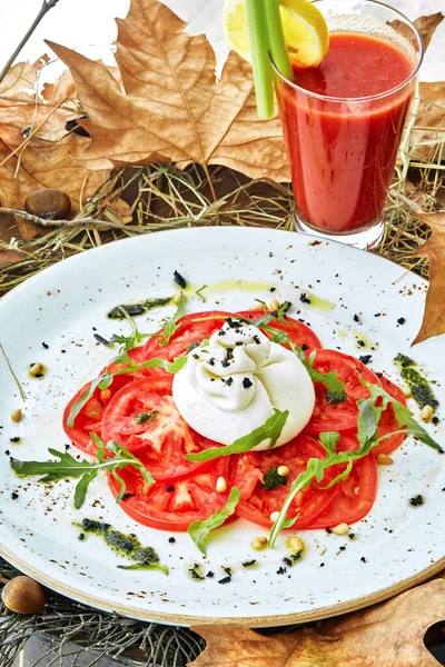 Tabakta domates olan bir kase burrata.
