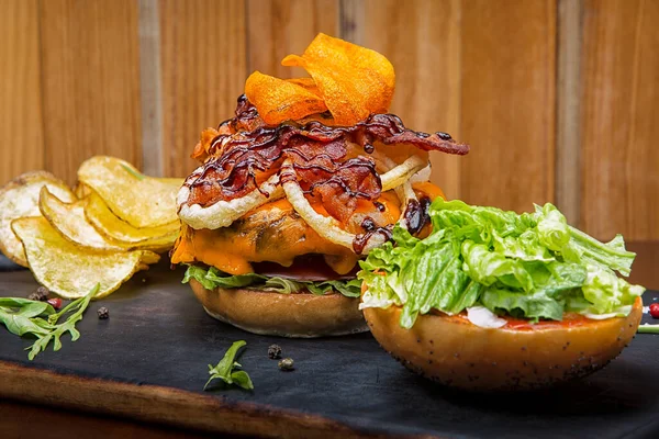 Tahta bir masanın üstünde oturan bir hamburger.