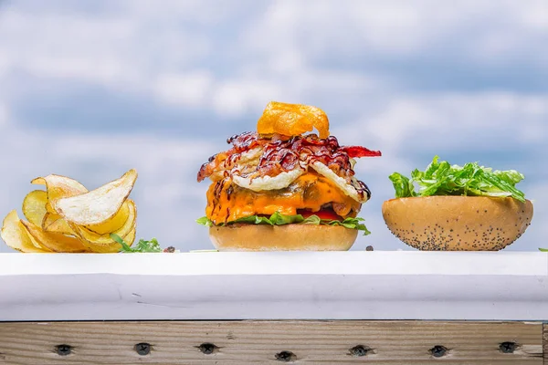 Tahta bir masanın üstünde oturan bir hamburger.