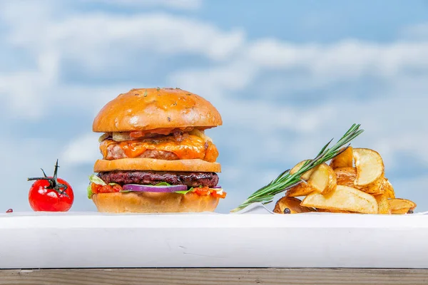 Tahta bir masanın üstünde oturan bir hamburger.