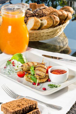 Bir tabak kebap, bir sürahi meyve suyu ve bir tabak ekmek.