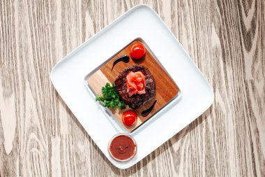 Biftek fileminyon ve sebzeli beyaz bir tabak.