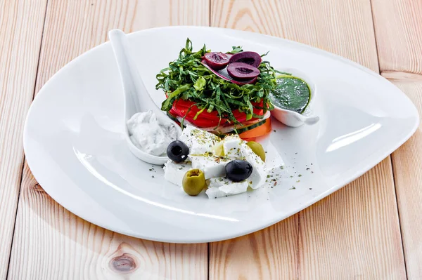 Peynirli sebze salatası ve bir tabak yemek.