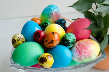 Paskalya yumurtaları. Kristal bir vazoda güzel boyanmış tavuk ve bıldırcın yumurtası.