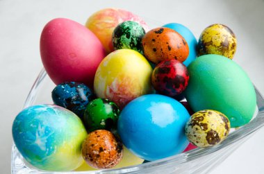 Paskalya yumurtaları. Kristal bir vazoda güzel boyanmış tavuk ve bıldırcın yumurtası.