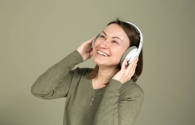 Karantina ve tecrit sırasında nasıl zaman geçirilir? En sevdiğin müziği dinle. Yeşiller içindeki genç ve güzel bir kadının en sevdiği müziği dinlemesi ve eğlenmesi..