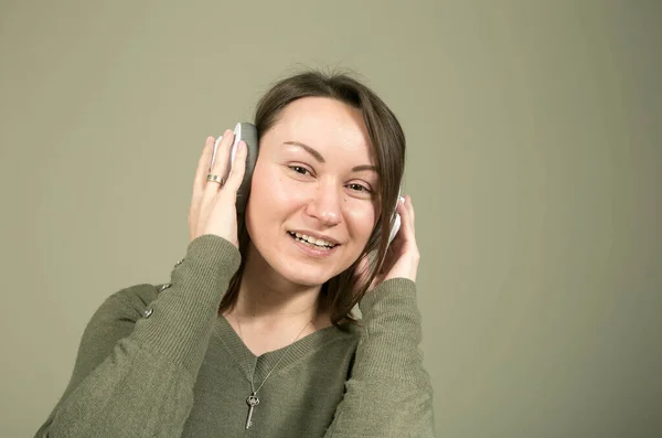 在检疫和隔离期间如何度过时间 听你最喜欢的音乐 一个穿着绿色衣服的年轻貌美的女人听着她最喜欢的音乐的心情和享受 — 图库照片