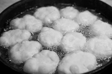 Karantina ve izolasyon süresince evde nasıl zaman geçireceksin? Yemek pişirmek için hobiler. Adım 8. Belyashlar yüksek sıcaklıkta kızartılmış tavada köpüren sebze yağıyla pişirilir ve eller onları çatalla çevirir.