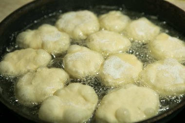 Karantina ve izolasyon süresince evde nasıl zaman geçireceksin? Yemek pişirmek için hobiler. Adım 8. Belyashlar yüksek sıcaklıkta kızartılmış tavada köpüren sebze yağıyla pişirilir ve eller onları çatalla çevirir.