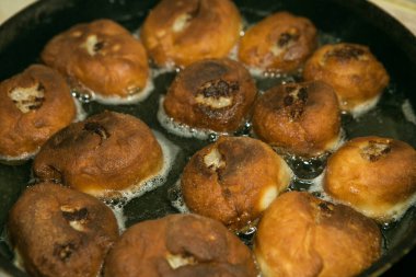 Karantina ve izolasyon süresince evde nasıl zaman geçireceksin? Yemek pişirmek için hobiler. Adım 8. Belyashlar yüksek sıcaklıkta kızartılmış tavada köpüren sebze yağıyla pişirilir ve eller onları çatalla çevirir.