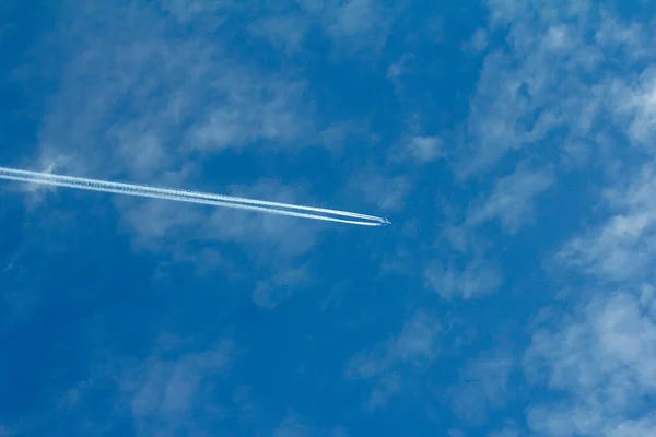 Pesawat Dalam Penerbangan Dengan Ekor Knalpot Terhadap Langit Biru Dengan — Stok Foto