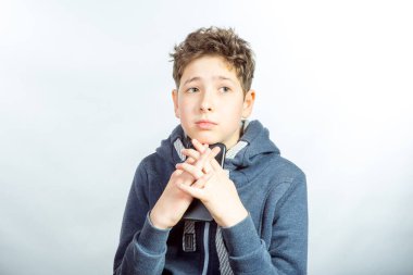 Cep telefonu kullanan genç bir adamın duyguları ve neşesi. Gri spor ceketli genç bir adamın resmi. Arka planda baskın ışık gölgeleri var.