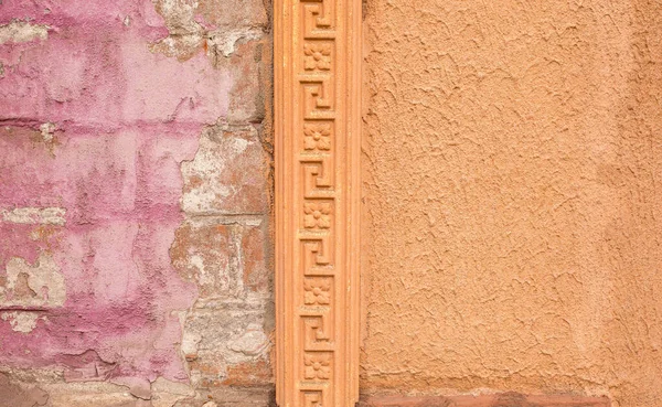 The exterior frieze is old combined with red brick and decorative plaster. Unusual background and texture. Computer desktop wallpaper.