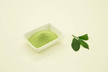 Japon çayı. Matcha Latte çayı. Limon yaprağı Beyaz arka planda beyaz bir kasede izole edilmiş..