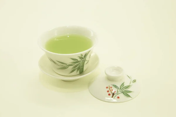 Japanese tea. Matcha latte tea. Green tea in a beautiful traditional oriental cup with saucer. Isolated in a white bowl on a white background.