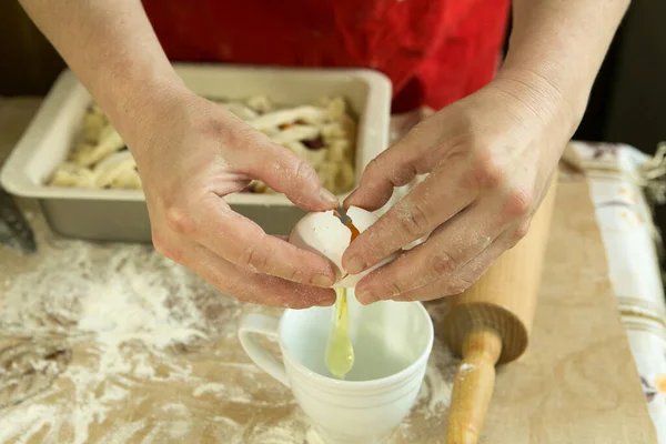 Mom\'s pies. Mom prepares a mixture of eggs to grease the cake before baking. Moms hands. Cooking during quarantine.