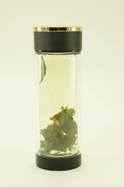 Çin yeşil çayı. Basıncı normale döndürmek için çay. Basıncı normale döndürmek için çay çift cam termo kapta demlenir. Beyaz bir arkaplanda izole edilmiş