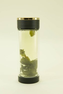 Çin yeşil çayı. Basıncı normale döndürmek için çay. Basıncı normale döndürmek için çay çift cam termo kapta demlenir. Beyaz bir arkaplanda izole edilmiş