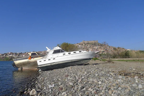 Barco dejado por los refugiados con el castillo de Molivos en el fondo — Foto de Stock