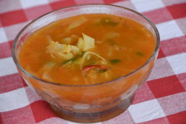 Kırmızı masa örtüsünde servis edilen Rus çorbası..