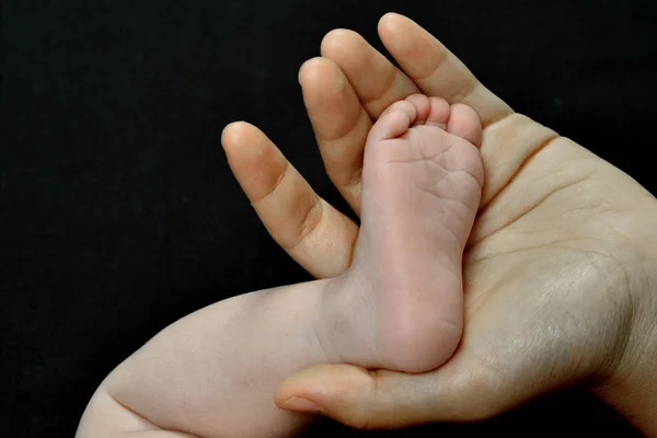 Motherhand and baby foot — Stock Photo, Image