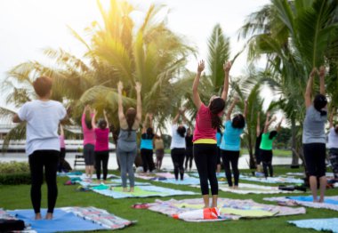 Yoga sınıfındaki bir park güneş ışığı ile pratik kadın gurup 