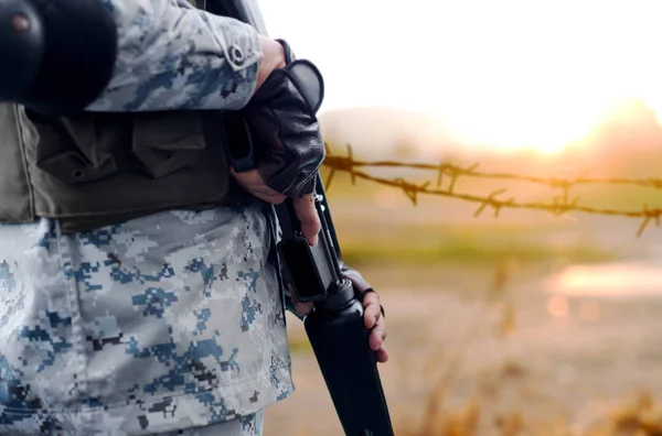 Exército de foco selecionado com arma de rifle com fio de fundo desfocado — Fotografia de Stock