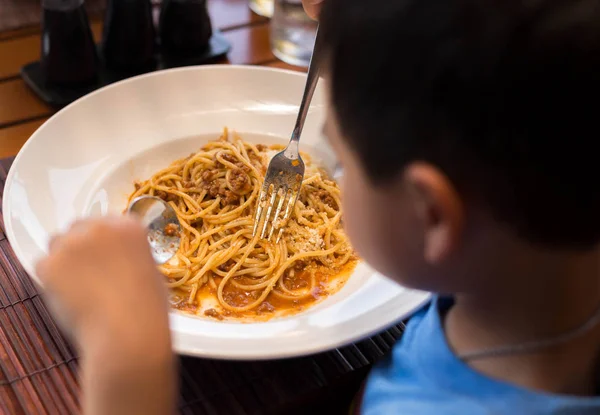 Выбранный фокус Маленькому ребенку нравится есть спагетти с болонами — стоковое фото