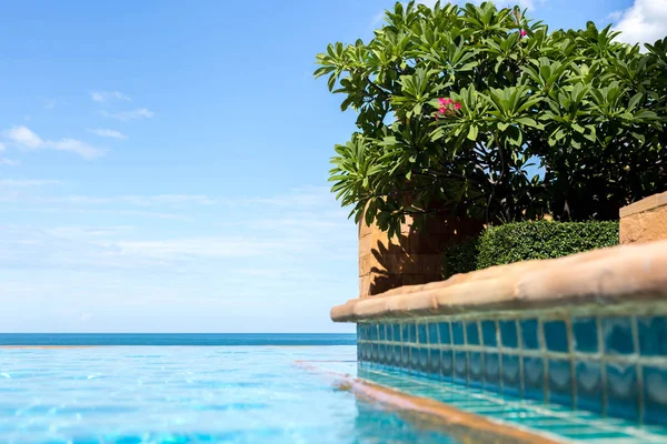 Plumeria vermelha ou flor de frangipani com céu azul e praia — Fotografia de Stock