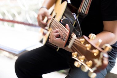 Capo klibi ile akustik gitar oynarken adam Practicing 