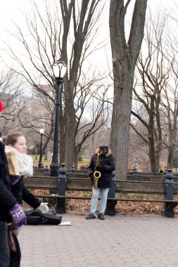 New York'taki Central Park'ta bir saksafon oynamaya adam