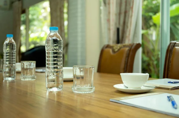 Bottles of water and cup of coffee on wooden table in conference — Stock Photo, Image