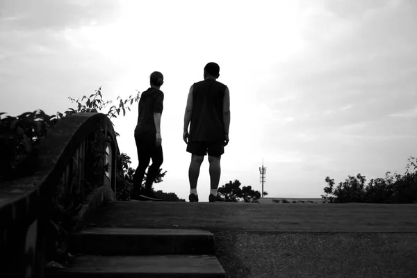 Silhouette contrast Unidentified couple jogger standing on the b — Stock Photo, Image