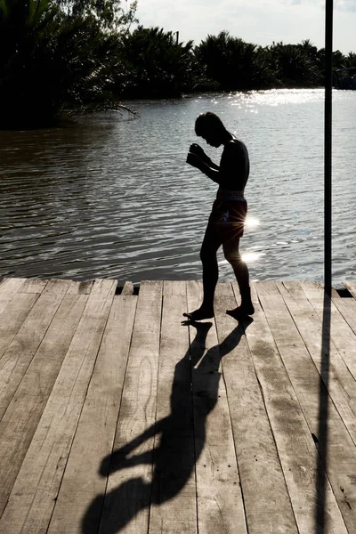 Silhouette Thai Boxer training Thai boxing in sunset background