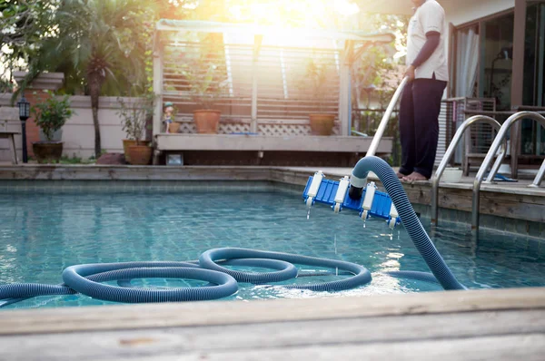 Homem de limpeza piscina com aspirador de tubo — Fotografia de Stock
