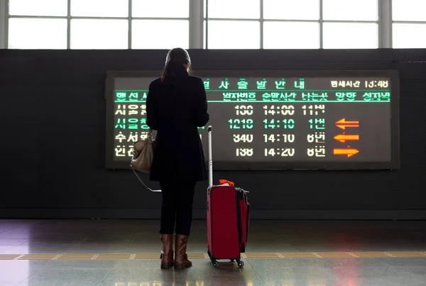 Kırmızı Çanta ayakta havaalanında uçuş t ön kadınla — Stok fotoğraf
