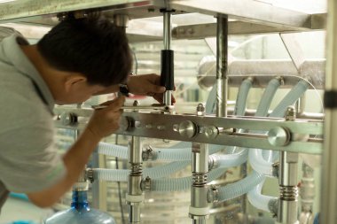 Kimliği belirsiz adam içme suyu için bir makine tamir