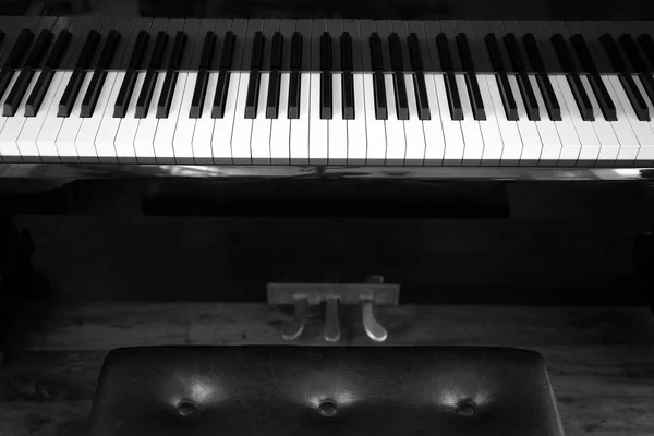 Ключи от фортепиано с кожаным стулом — стоковое фото