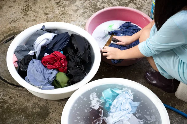女性の手の服 b で木の板の汚れた服を洗濯 — ストック写真