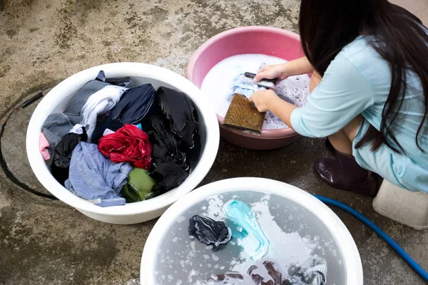 Женщина руки стирает грязную одежду на деревянной доске с одеждой б — стоковое фото