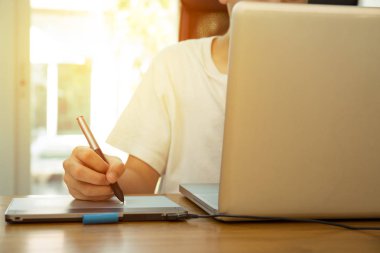 Genç öğrenci ahşap masa üstünde laptop üzerinde çalışıyor 