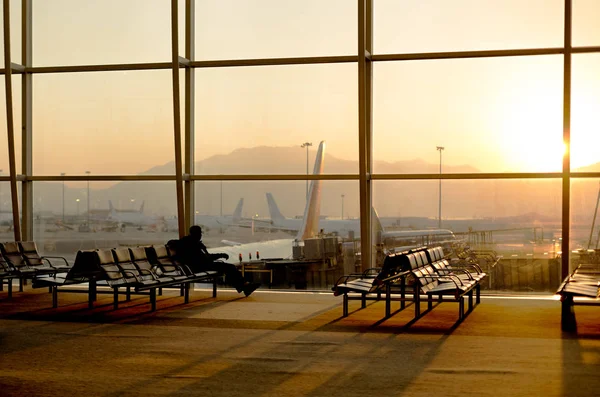 Passenger sitting in a lobby airport waiting for flight in silho — Stock Photo, Image
