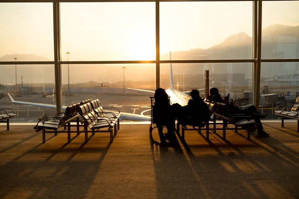 Passenger sitting in a lobby airport waiting for flight in silho — Stock Photo, Image