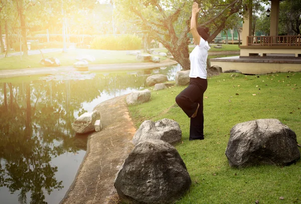 Mujer asiática haciendo yoga en la mañana en el parque — Foto de Stock