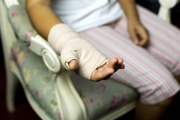 Vrouw zitten op een stoel met Splint gebroken bot op haar hand — Stockfoto