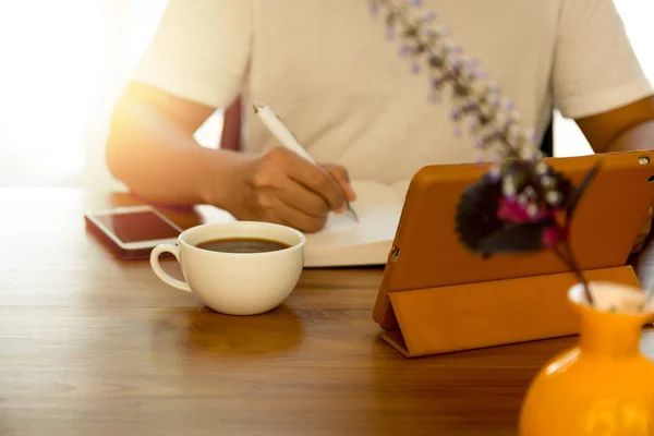 Biznesmen, pisanie na notebooku z notatnika na stole — Zdjęcie stockowe